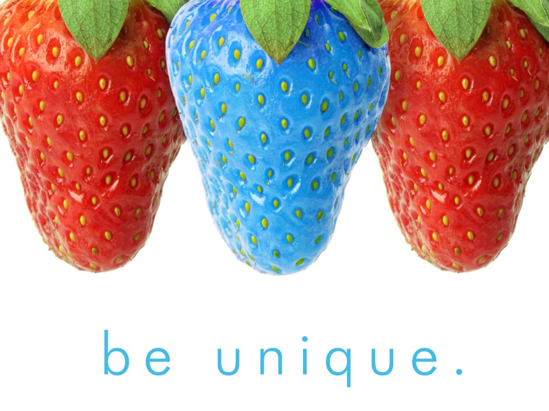 Fraises de couleur sur fond blanc avec une fraise de couleur bleue au centre. Inscription "Be unique" en bleu en bas de la page.